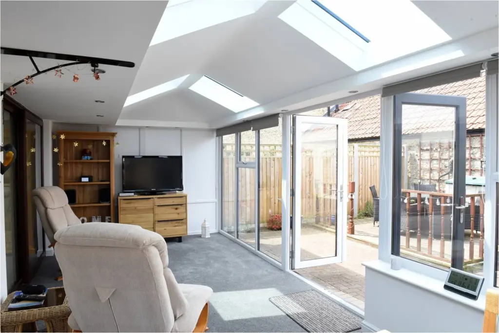 white sunroom with glass fron and 4 roof windows